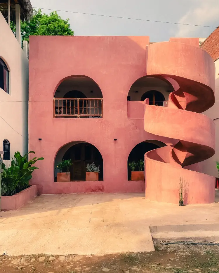 Fachada rosa de Casa Amapa con escalera caracol